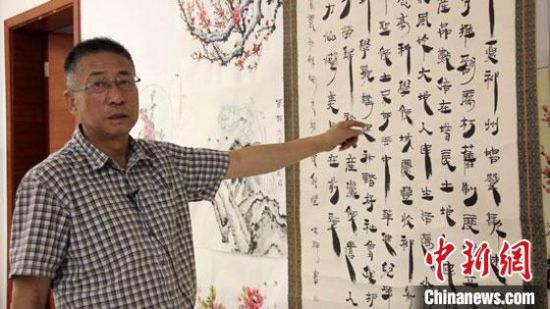 圖為朱群和他的敦煌漢簡(jiǎn)書(shū)體?！「攥?攝