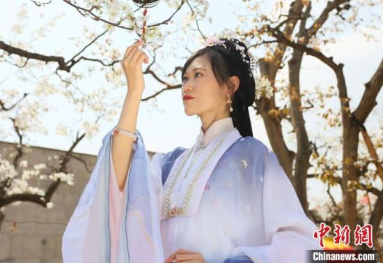 圖為蘭州青年身穿漢服在百年梨園賞景?！「哒?攝