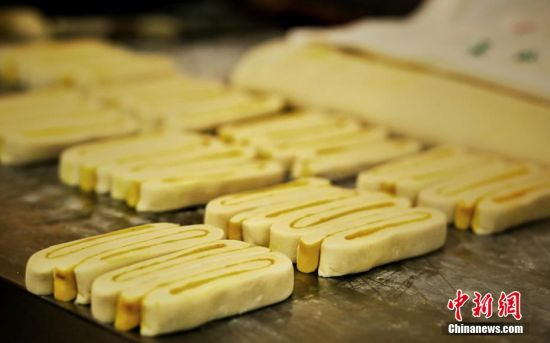 圖為面劑被涂上胡麻油，切成條狀用作月餅的花型制作。張文 攝