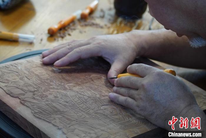 圖為徐晉林湊近木板，近距離制作雕版畫?！【琶赖┰?　攝