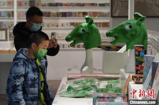 圖為“神馬來了”銅奔馬頭套吸引參觀者駐足?！【琶赖┰?攝