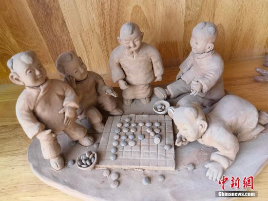圖為泥塑作品展現(xiàn)下棋場景。 劉玉桃 攝