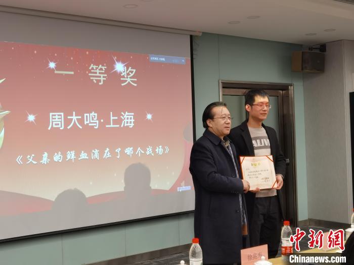 圖為作家、西北師范大學新聞與傳媒學院院長徐兆壽頒發(fā)一等獎證書，代領(lǐng)獎?wù)呱吓_領(lǐng)獎?！钅?攝