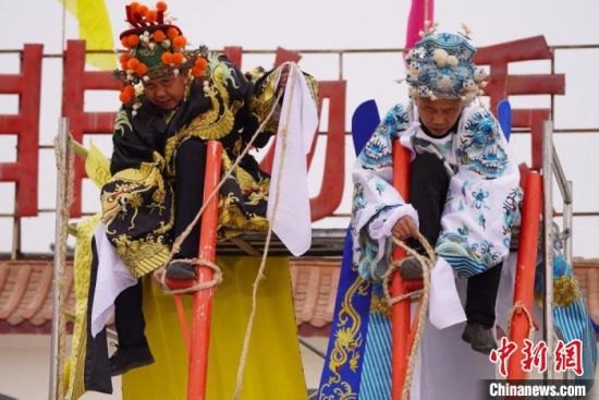 圖為“苦水高高蹺”表演者通過麻繩將腳固定在腳踏板，并在腿部纏繞六七圈?！【琶赖┰?攝