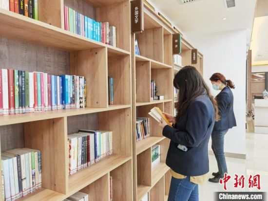 圖為在甘肅公航旅建設(shè)集團(tuán)有限公司的職工書屋，職工挑選書籍。　徐雪 攝