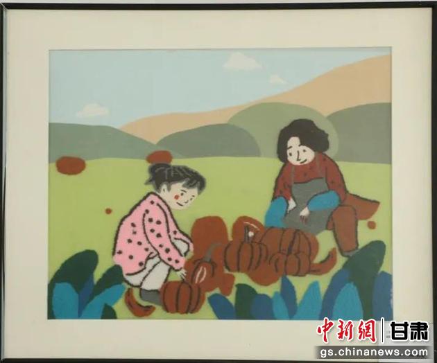 嘉峪關(guān)市新城鎮(zhèn)新城村農(nóng)業(yè)產(chǎn)業(yè)園區(qū)內(nèi)，母女兩人在摘南瓜。刺繡 馬艾米乃 繡稿 敬紅霞