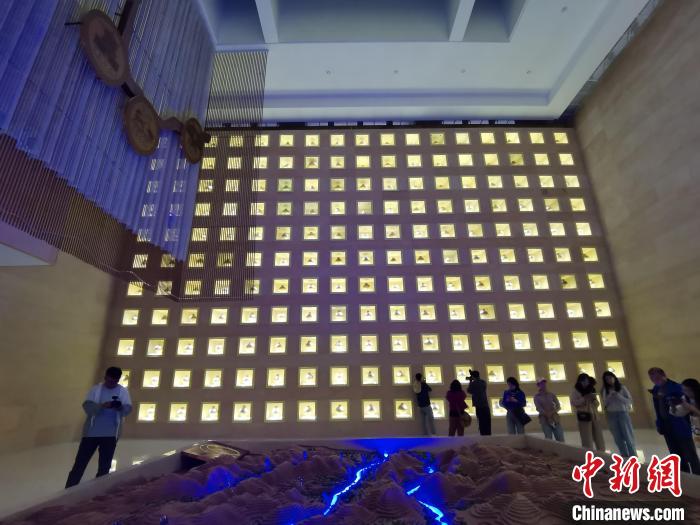 圖為河湟文化博物館序廳的左右彩陶墻放置的374件彩陶?！?zhí)砀?攝