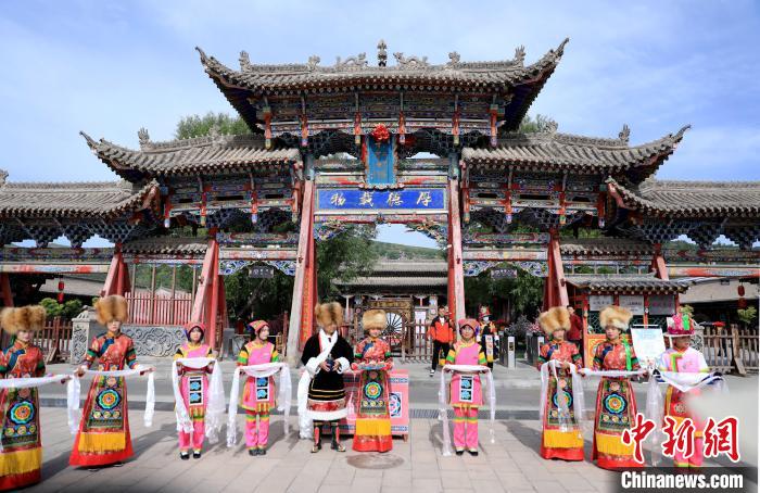 圖為身穿土族服飾的工作人員迎接訪客?！⊙Φ?攝