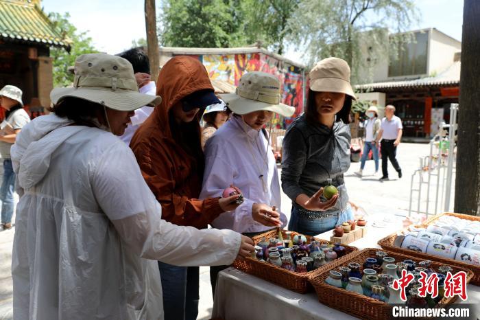 圖為民眾挑選手工藝產(chǎn)品?！⊙Φ?攝