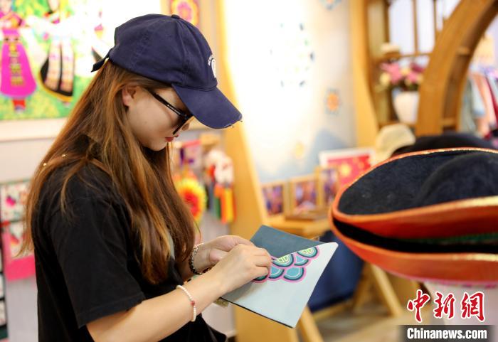 圖為民眾體驗(yàn)國家級(jí)非遺項(xiàng)目盤繡技藝?！⊙Φ?攝