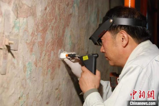 敦煌研究院研究員樊再軒進行壁畫修復(fù)。(資料圖)張云文 攝