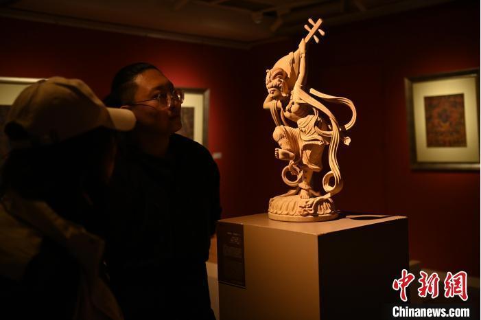 圖為季茂杰向參觀者介紹自己創(chuàng)作敦煌木雕的過程。李亞龍 攝</p>
<p>