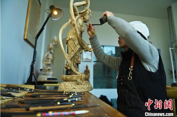 圖為季茂杰進(jìn)行敦煌元素的木雕創(chuàng)作。李亞龍 攝</p>
<p>