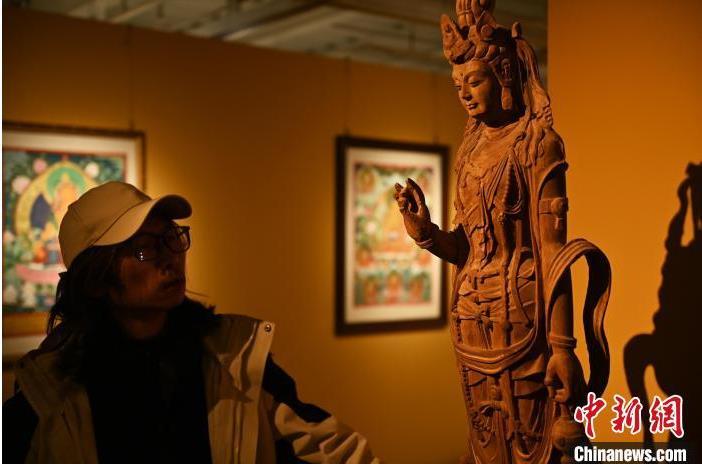 圖為季茂杰觀察自己創(chuàng)作的敦煌木雕。李亞龍 攝</p>
<p>