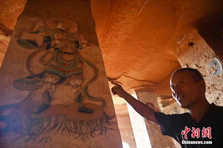 7月15日，甘肅省平?jīng)鍪袥艽h百里石窟長廊羅漢洞石窟內(nèi)，該窟文保員郭建平介紹窟內(nèi)石刻彩繪壁畫。郭建平家中三代人曾自發(fā)保護(hù)羅漢洞石窟。羅漢洞石窟遺存40余個(gè)窟龕，以北魏至清代風(fēng)格為主。中新社記者 李亞龍 攝</p>
<p>