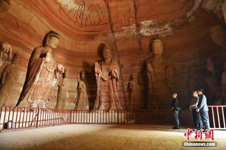 7月15日，游人參觀甘肅省平?jīng)鍪袥艽h百里石窟長廊中的南石窟寺1號窟。百里石窟長廊位于涇川縣境內(nèi)，由512個(gè)石窟、5眼窟中石井組成，現(xiàn)存王母宮石窟、鳳凰山石窟、南石窟寺、丈八寺石窟、羅漢洞石窟、太山寺石窟等規(guī)模較大的石窟群，還有數(shù)量眾多的小石窟群。南石窟寺開鑿于北魏永平三年，其中1號窟屬于大型七佛窟，七佛高達(dá)6米。中新社記者 李亞龍 攝