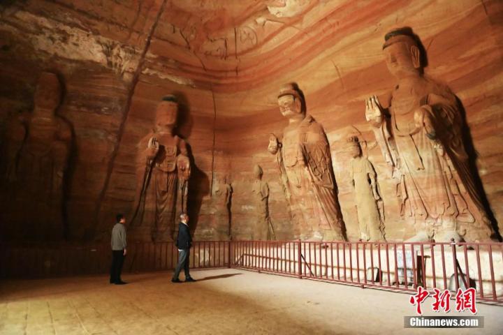 7月15日，游人參觀甘肅省平?jīng)鍪袥艽h百里石窟長廊中的南石窟寺1號窟。百里石窟長廊位于涇川縣境內(nèi)，由512個(gè)石窟、5眼窟中石井組成，現(xiàn)存王母宮石窟、鳳凰山石窟、南石窟寺、丈八寺石窟、羅漢洞石窟、太山寺石窟等規(guī)模較大的石窟群，還有數(shù)量眾多的小石窟群。南石窟寺開鑿于北魏永平三年，其中1號窟屬于大型七佛窟，七佛高達(dá)6米。中新社記者 李亞龍 攝