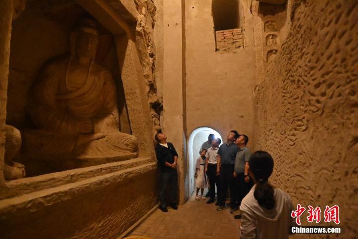 7月15日，游人參觀甘肅省平?jīng)鍪袥艽h百里石窟長廊中的王母宮石窟。百里石窟長廊位于涇川縣境內(nèi)，由512個(gè)石窟、5眼窟中石井組成，現(xiàn)存王母宮石窟、鳳凰山石窟、南石窟寺、丈八寺石窟、羅漢洞石窟、太山寺石窟等規(guī)模較大的石窟群，還有數(shù)量眾多的小石窟群。王母宮石窟又名千佛洞，該窟設(shè)計(jì)宏大，造像生動(dòng)，窟內(nèi)擁有造像數(shù)百尊，是較為珍貴的佛教文化歷史遺存。中新社記者 李亞龍 攝</p>
<p>