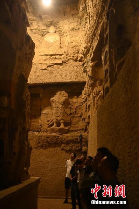 7月15日，游人參觀甘肅省平?jīng)鍪袥艽h百里石窟長廊中的王母宮石窟。百里石窟長廊位于涇川縣境內(nèi)，由512個(gè)石窟、5眼窟中石井組成，現(xiàn)存王母宮石窟、鳳凰山石窟、南石窟寺、丈八寺石窟、羅漢洞石窟、太山寺石窟等規(guī)模較大的石窟群，還有數(shù)量眾多的小石窟群。王母宮石窟又名千佛洞，該窟設(shè)計(jì)宏大，造像生動(dòng)，窟內(nèi)擁有造像數(shù)百尊，是較為珍貴的佛教文化遺存。中新社記者 李亞龍 攝</p>
<p>
