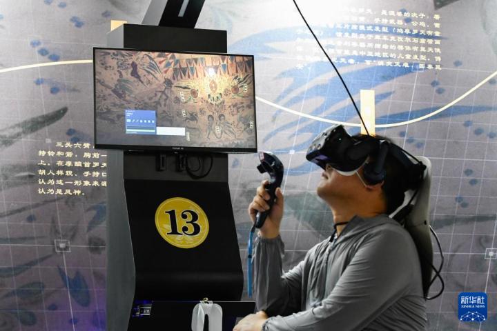 7月22日，游客借助VR設(shè)備沉浸式游覽莫高窟第285窟虛擬場景。新華社記者 郎兵兵 攝